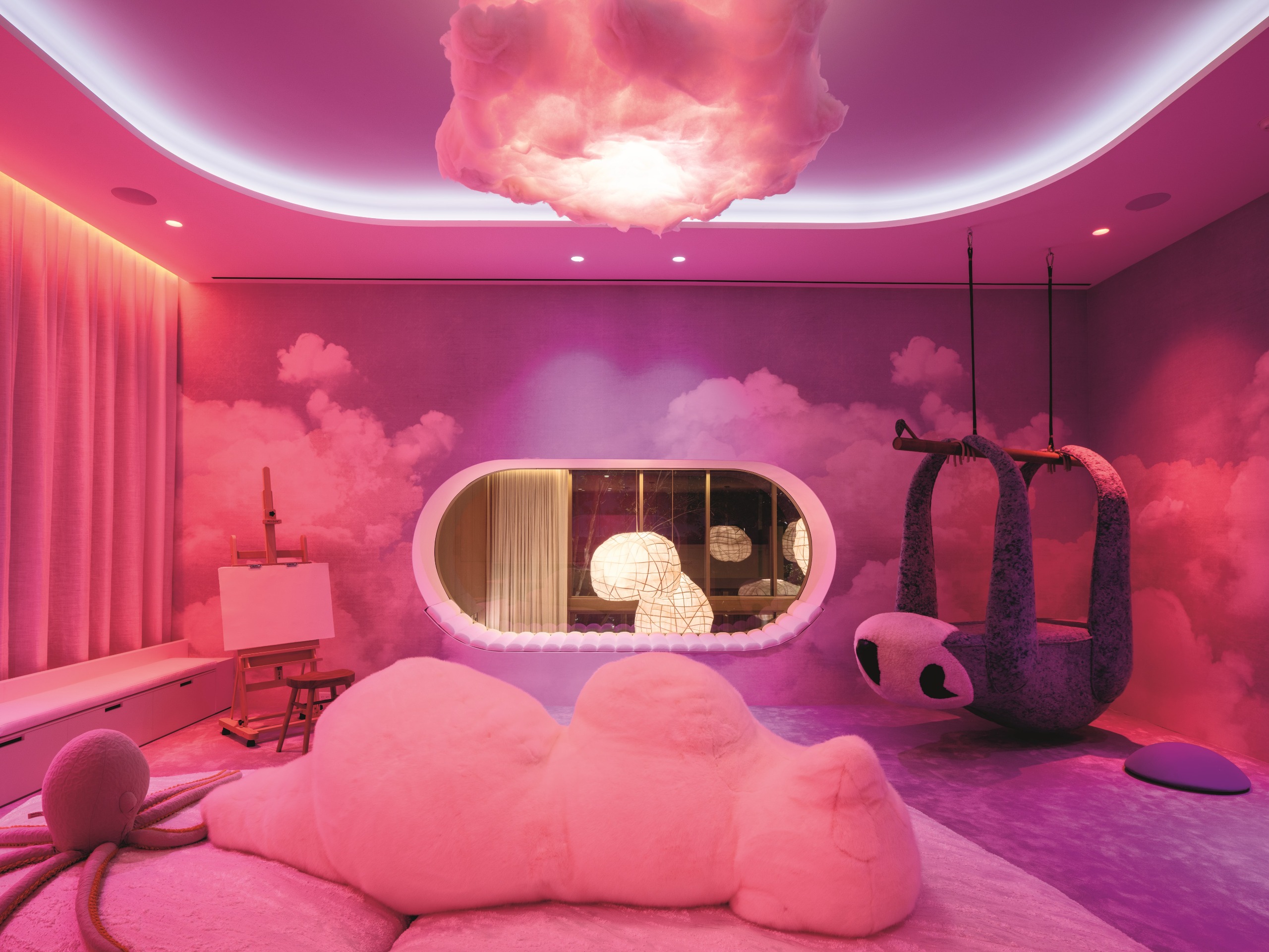 Theatrical interiors with art installation-like ceilings, a consistent yet striking palette, statement lighting in bold forms, and softly shaped furniture.