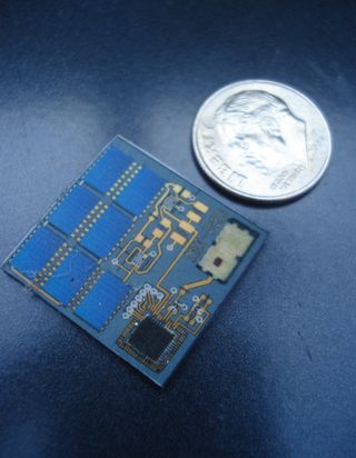 A potential satellite-on-a-chip alongside a dime.