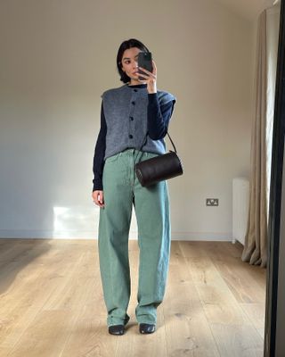 Influencer wears green jeans with a grey knit.