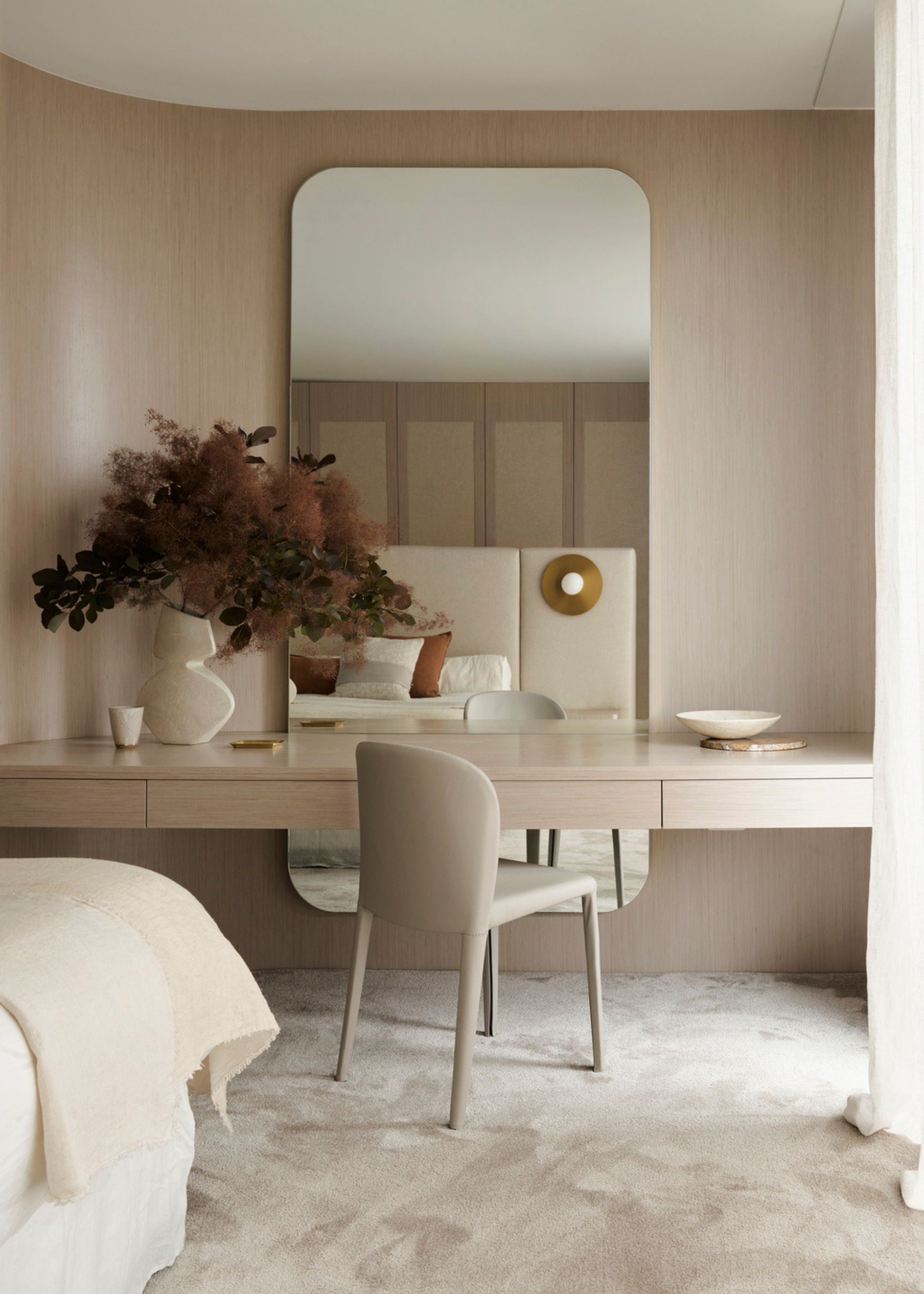 A dressing table in a bedroom with a muted, dramatic bouquet