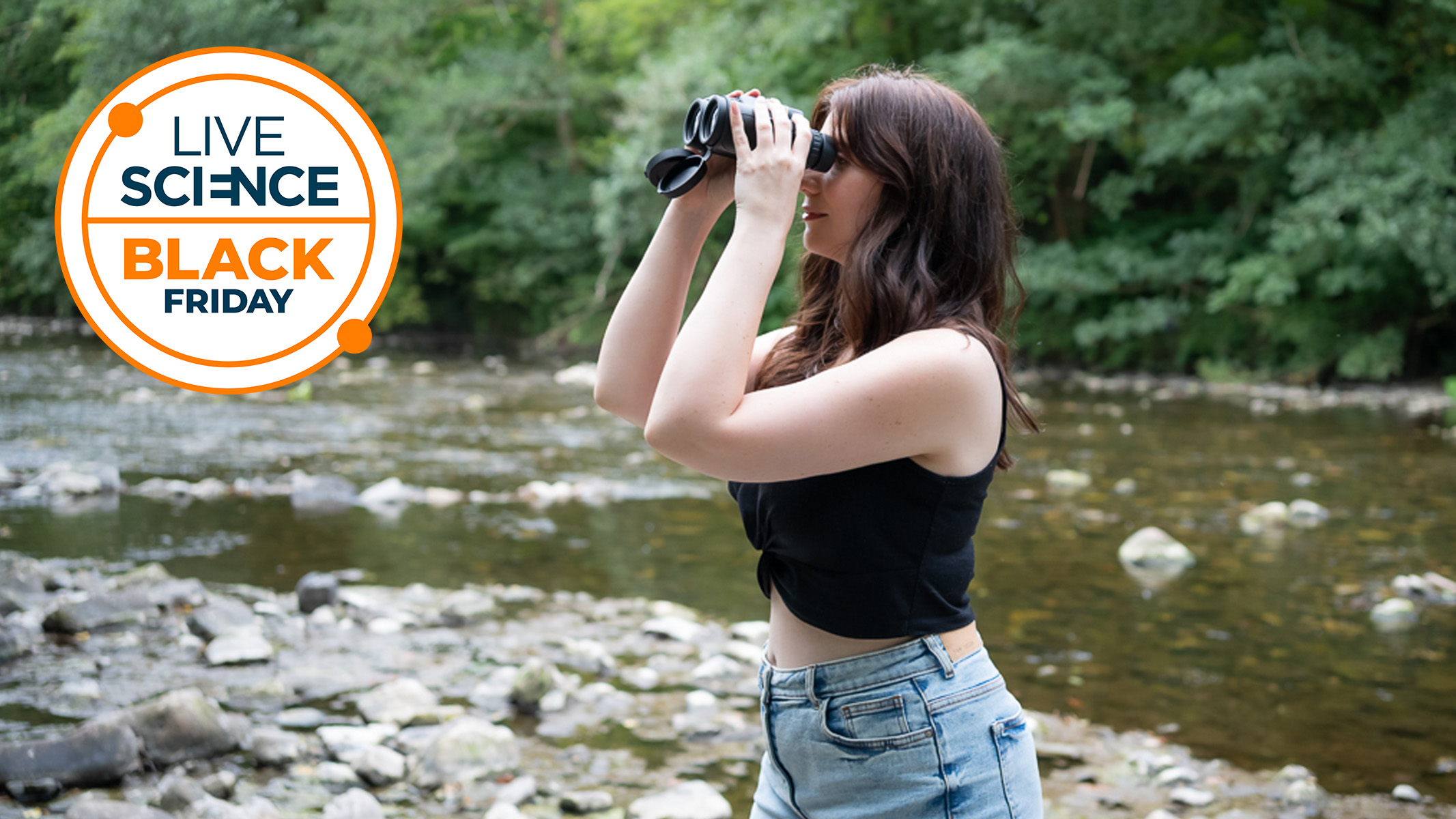 Kimberley Lane using a pair of binoculars next to a river