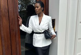 Fashion influencer in luxurious blazer and skirt.