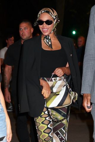 Beyonce wears Pucci pants with a matching bag and scarf.