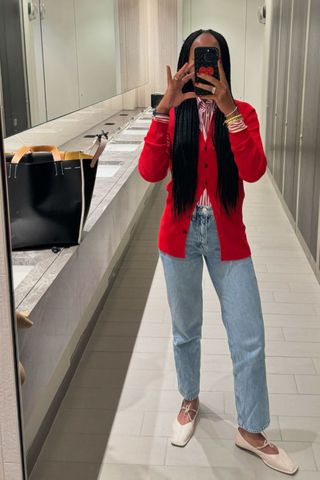 @thandimaq wearing a cardigan and jeans