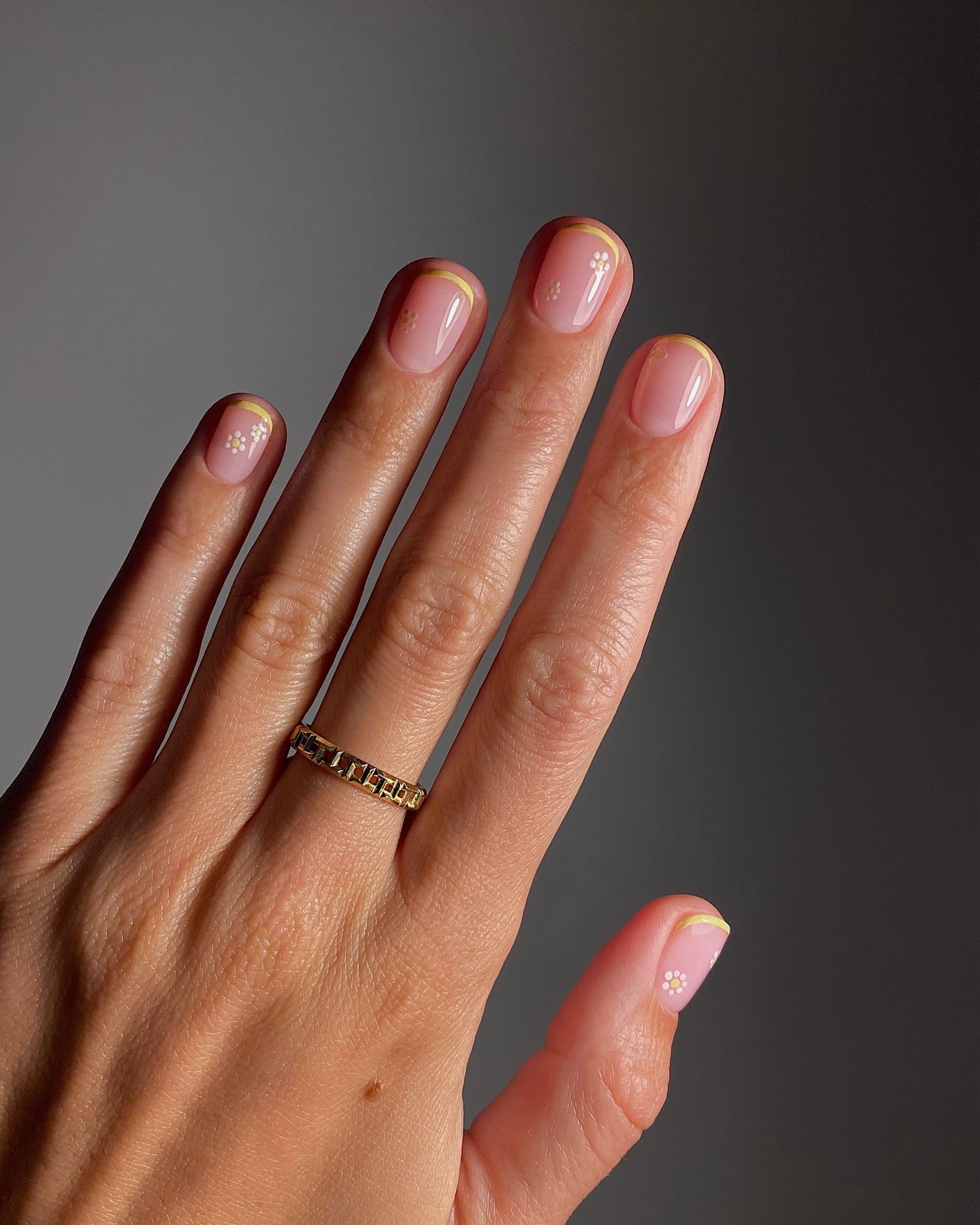 A manicure featuring a playful daisy design and yellow tips by Mate Janova