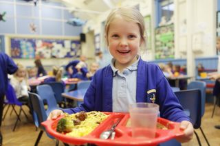 young girl at school with a school dinner
