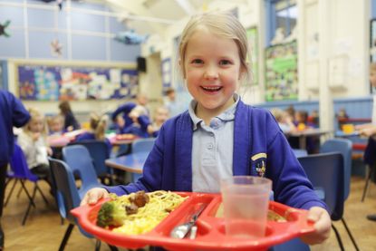 young girl at school with a school dinner