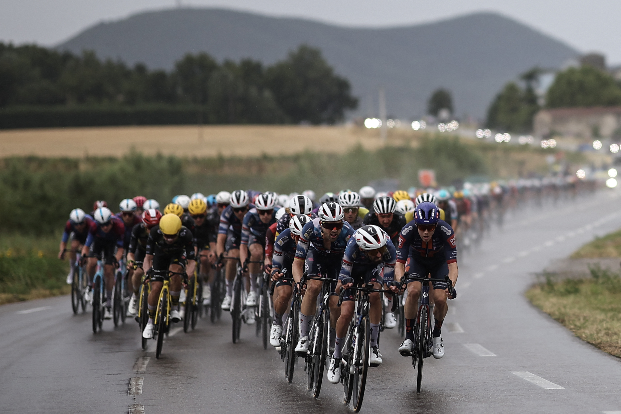 The pack of riders (peloton) cycles in the rain during the 17th stage of the 112th edition of the Tour de France cycling race, 160.4 km between Bollene and Valence, southern France, on July 23, 2025. (Photo by Anne-Christine POUJOULAT / AFP) (Photo by ANNE-CHRISTINE POUJOULAT/AFP via Getty Images)