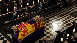 King Charles III places the the Queen's Company Camp Colour of the Grenadier Guards on the coffin during the Committal Service for Queen Elizabeth II