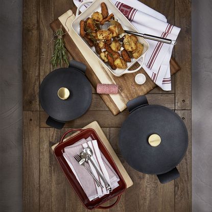 wooden board cast aluminium cassarole and white tray