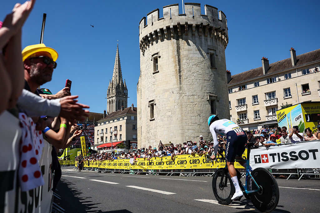 XDS Astana Team's Kazakh rider Yevgeniy Fedorov cycles past the Tour Leroy near the Saint Peter's church (seen rear) during the 5th stage of the 112th edition of the Tour de France cycling race, 33 km individual time trial starting and finishing in Caen, northwestern France, on July 9, 2025. (Photo by Anne-Christine POUJOULAT / AFP) (Photo by ANNE-CHRISTINE POUJOULAT/AFP via Getty Images)