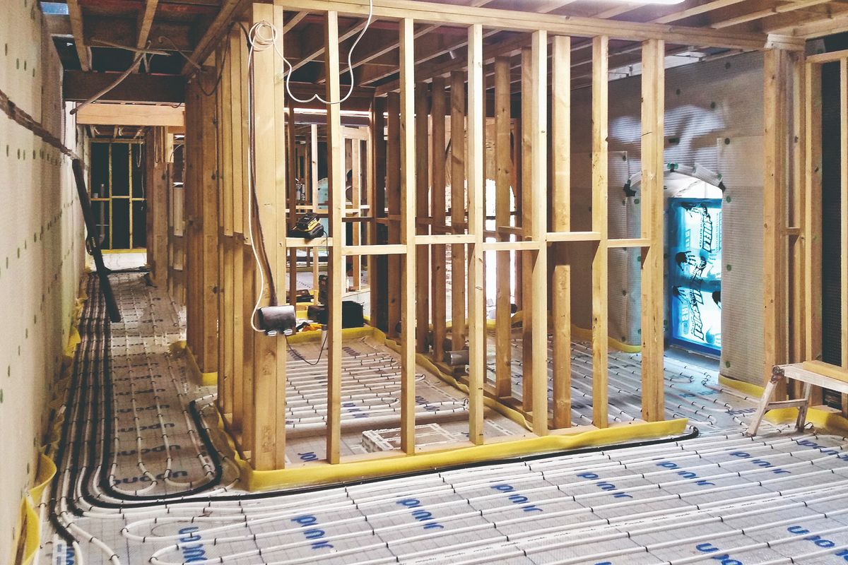 Underfloor heating pipes bring laid in a barn and stud walls being erected