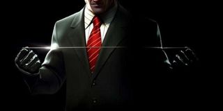 Agent 47 holds a garrote in Hitman.