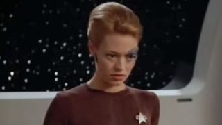 Jeri Ryan looking at Neelix unsure of herself.