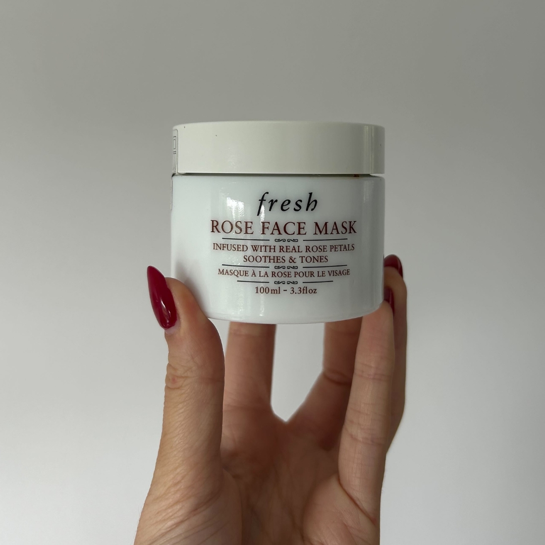 A close-up of Digital Beauty Writer, Sennen Prickett holding the Fresh Rose Face Mask, in front of a white wall