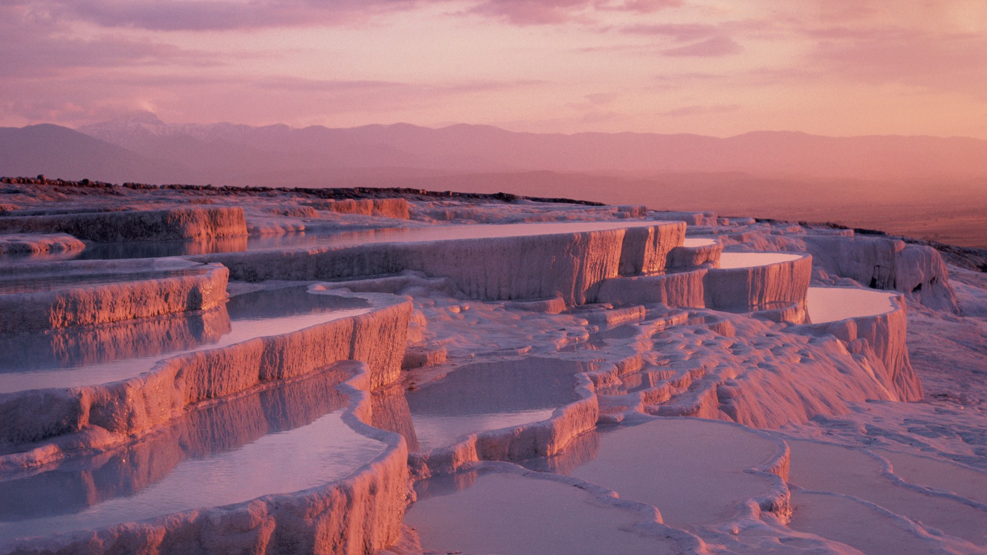 Dusky pink sunset over white layered deposits of calcium bicarbonate.