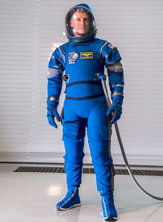 Former NASA astronaut Chris Ferguson tries on the "Boeing Blue" spacesuit.