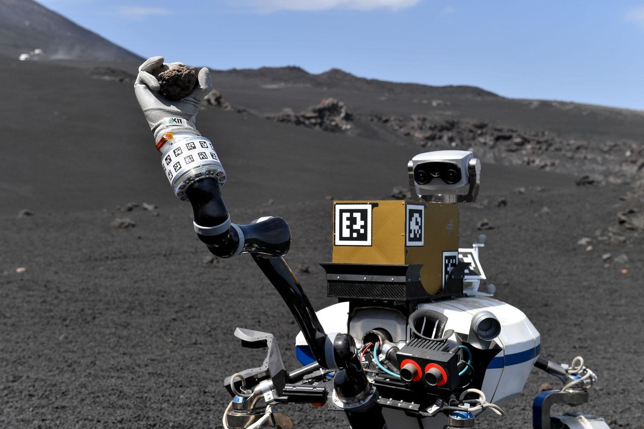 The Lightweight Rover Unit 2 built by the German Aerospace Center grabbing a rock during an exercise on the lunar-like slopes of Italy's Mount Etna.