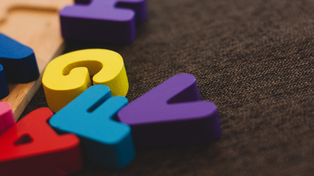 Wooden letter blocks scattered on a brown floor