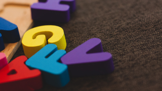 Wooden letter blocks scattered on a brown floor