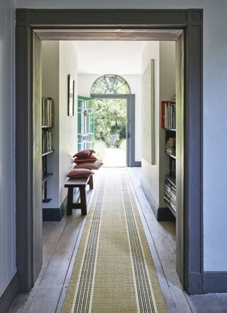 Hallway with striped runner and view out of front door