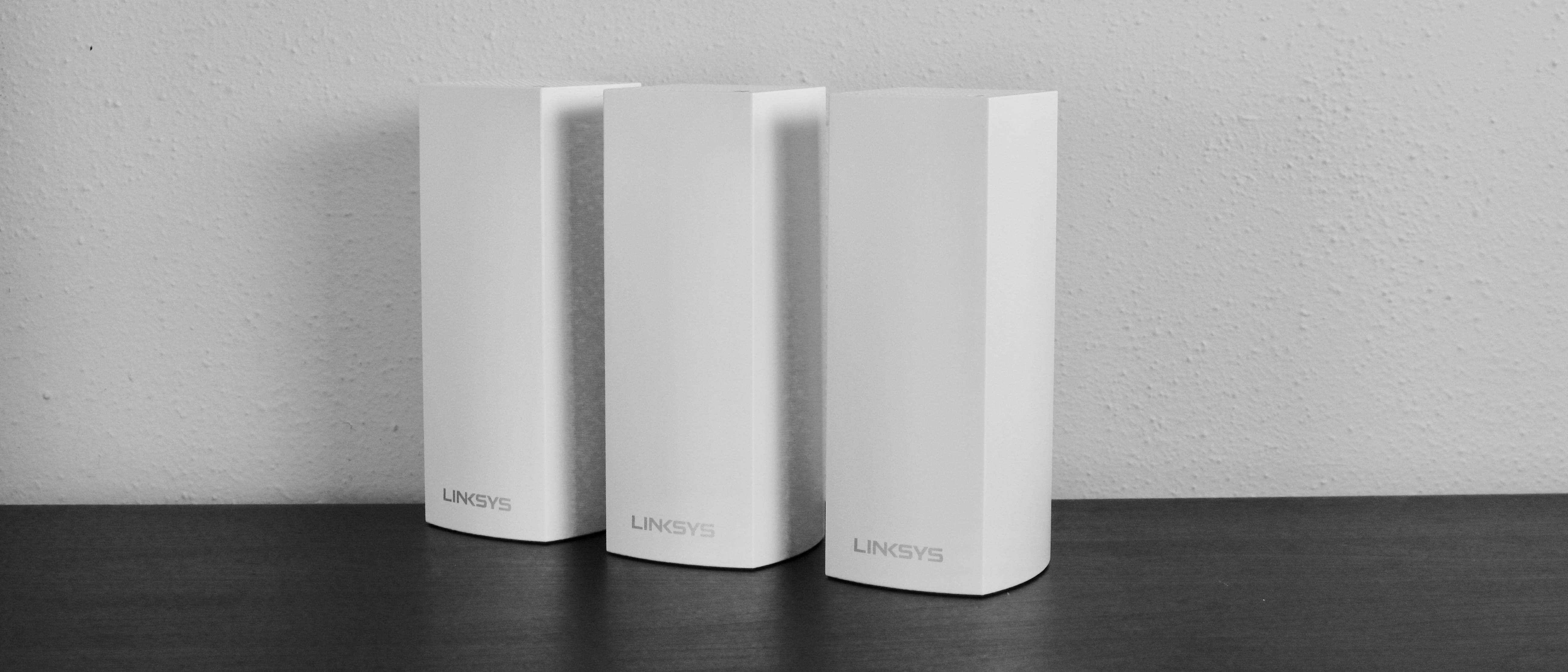 The Linksys Velop system on a dark surface against a gray background