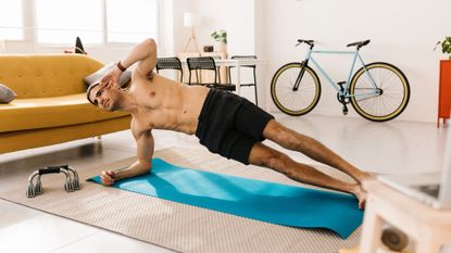A man performing a side plank as part of a core workout at home