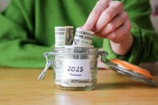 Person puts money in a money jar