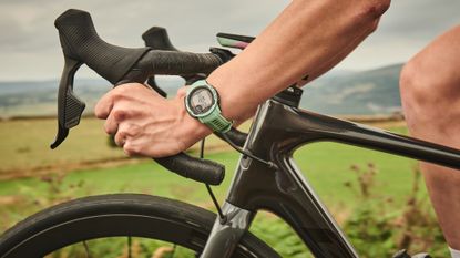 Female cyclist wearing a Garmin smartwatch while cycling