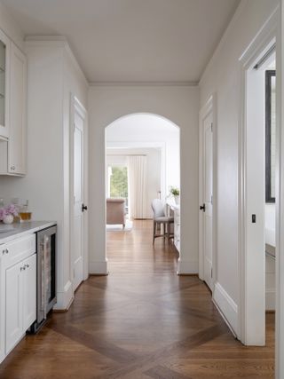 A white hallway with dark wooden floor