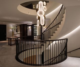 grand hallway with statement light and access to basement from elliptical staircase