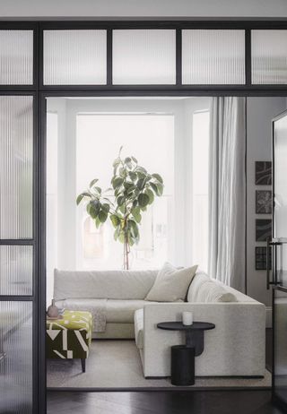 A living room with white sofa and white curtains
