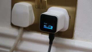 Anker Nano Charger plugged into a wall socket, with the smart display showing Auto charging at 42W.