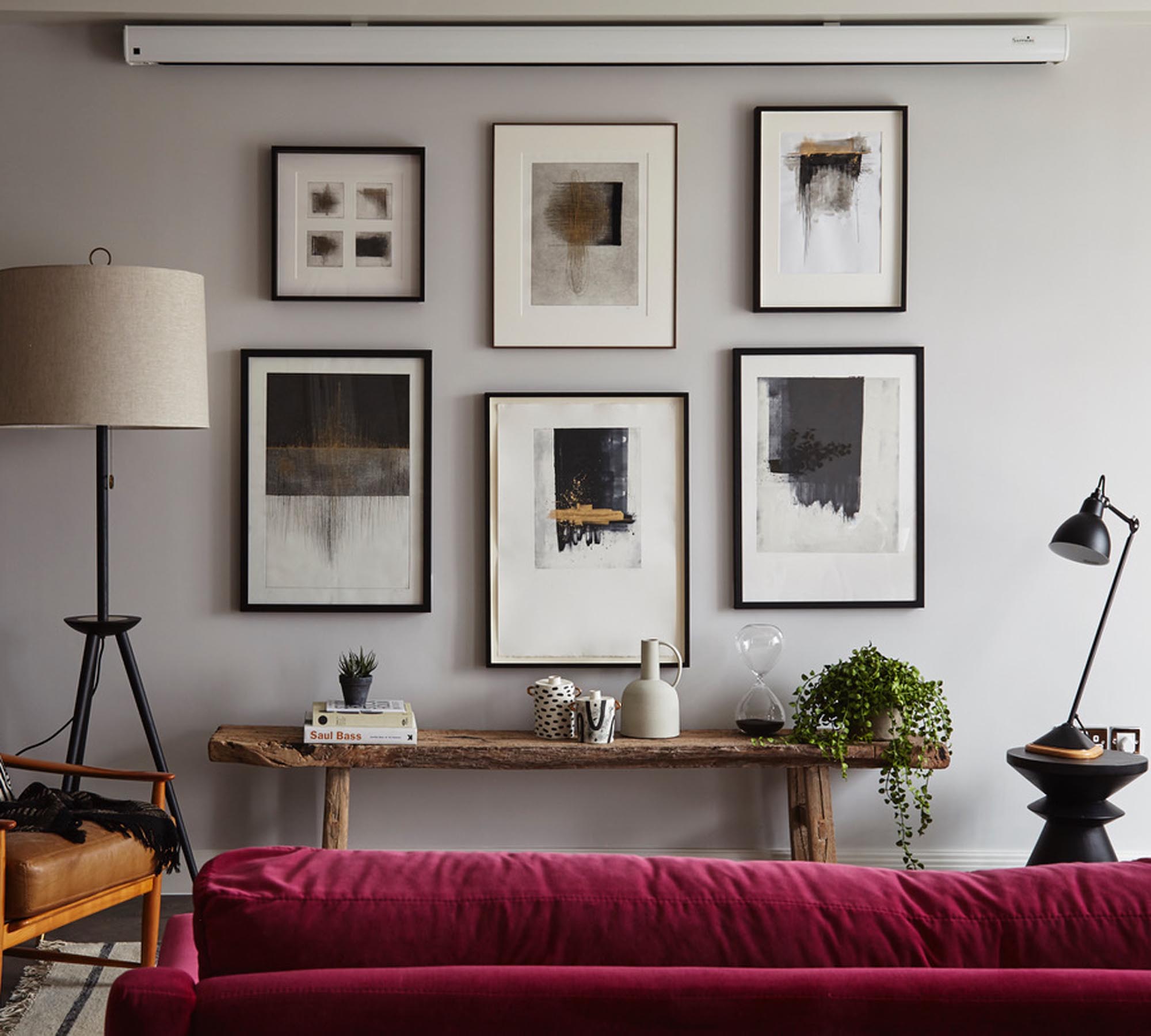 TV projector on the wall with a pink sofa and framed artwork