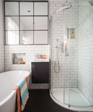 white bathroom with bathing glass partition and black flooring