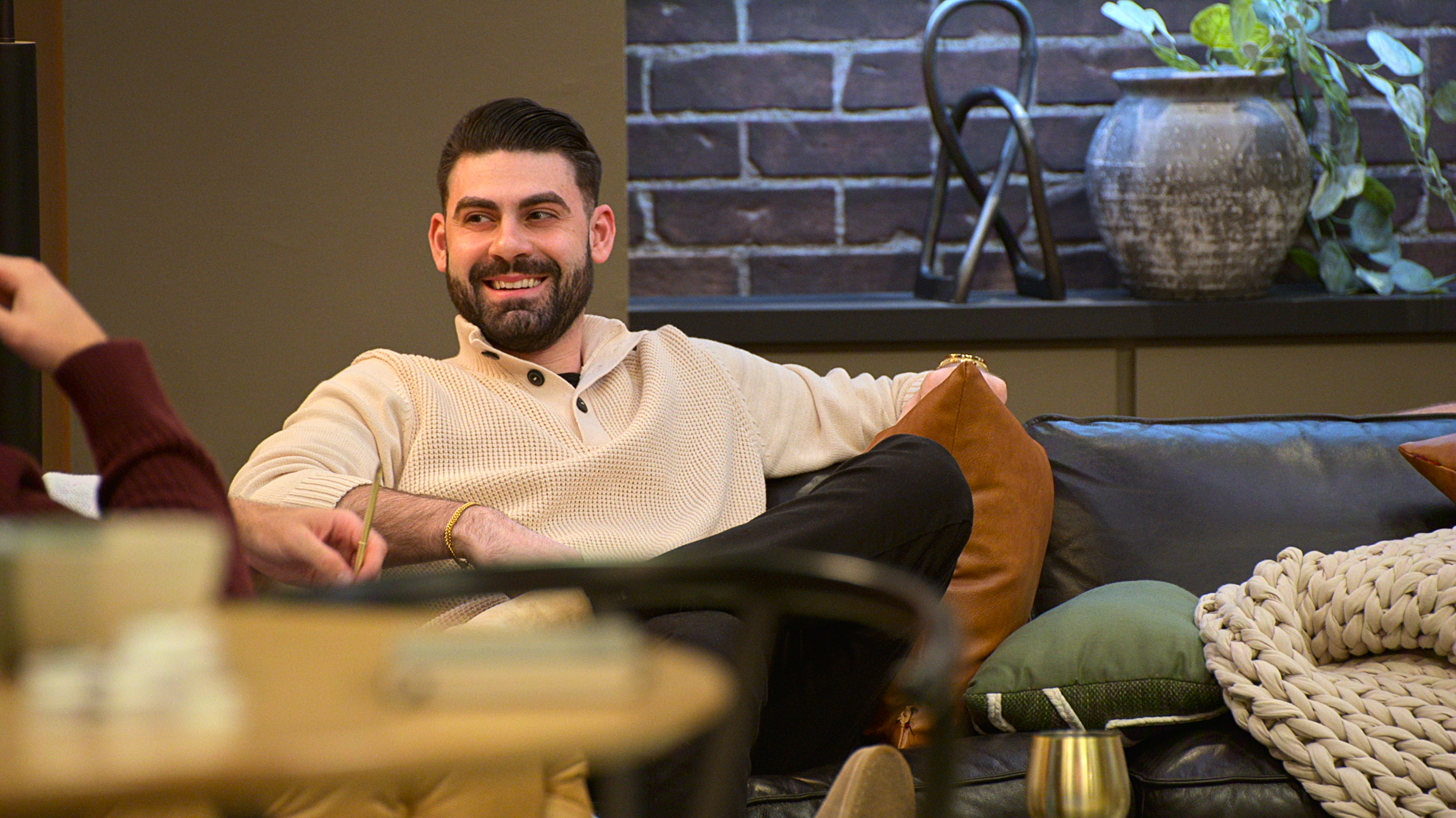 mike gibney sitting on a couch talking to another male contestant on love is blind season 10