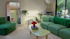 Contemporary living room with green sofa and red mushroom lamp