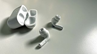 AirPods Pro on a table next to their case