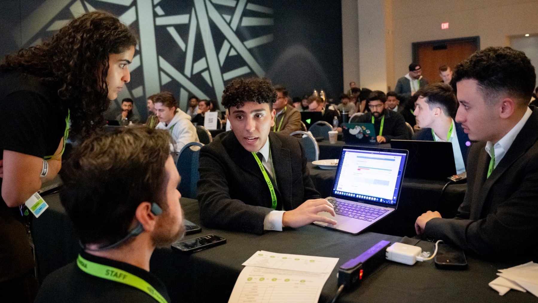 A group of young men around a laptop at NVIDIA GTC