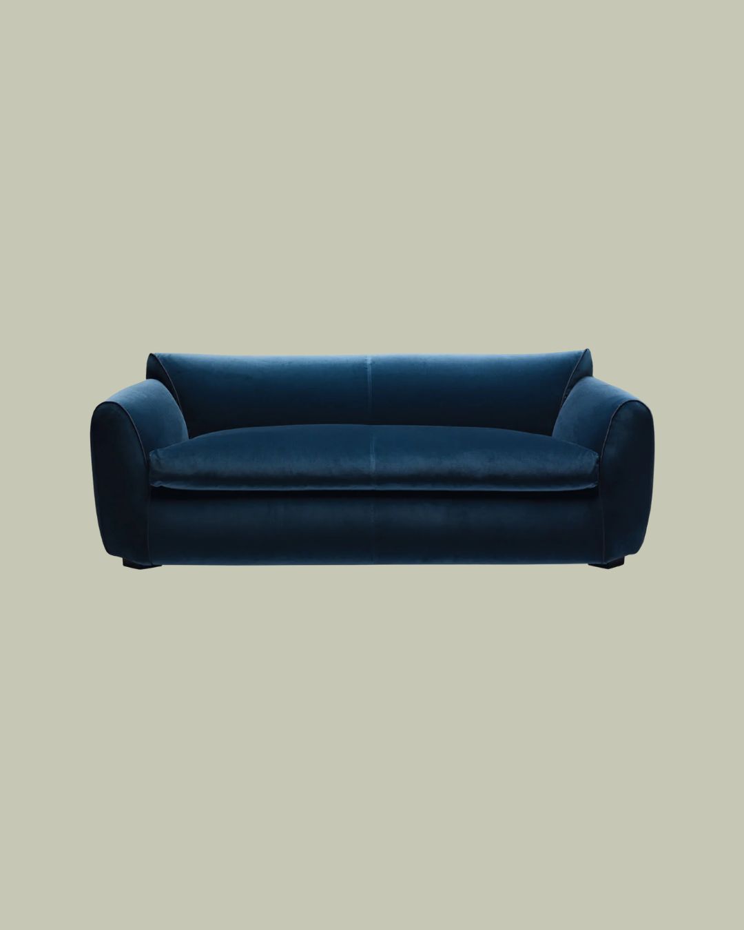 Sexy Beast Blue Velvet Sofa against pale green background.