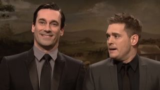 A smiling Jon Hamm stands next to a concerned Michael Bublé on SNL