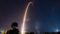 A bright arc streaks through the night sky