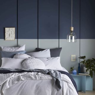 white bed linen in a denim blue split painted bedroom with painted panelling