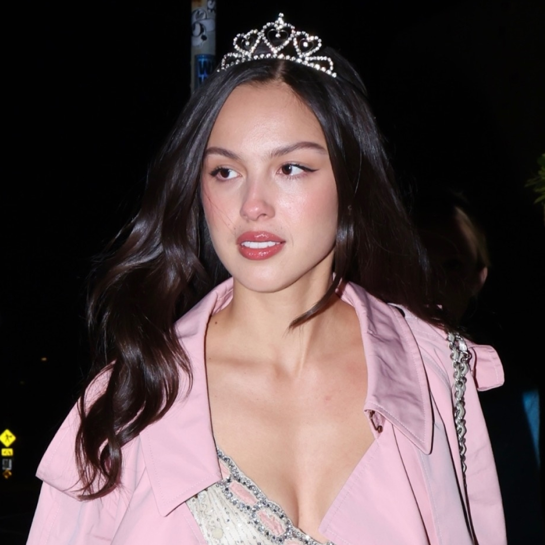 Olivia Rodrigo is pretty in pink on her birthday, pairing a tiara with a Barbie pink duster coat, a glittery dress, and bubblegum pink mules