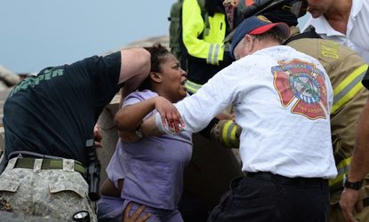 Workers help free a woman trapped at the Moore hospital complex on Monday.