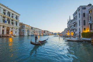 A gondolier on a peaceful canal in Venice, Italy.