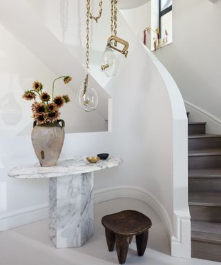 staircase with white walls and marble console