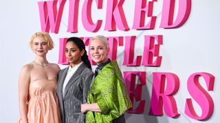 Jessie Buckley, Anjana Vasan and Olivia Colman (L-R) at the European Premiere for Wicked Little Letters on February 13, 2024 standing in front of a pink Wicked Little Letters sign.
