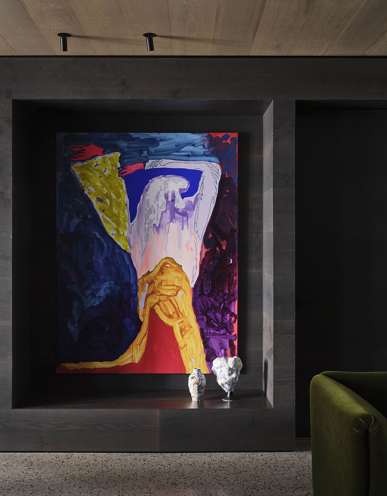 An artwork hangs within a built-in wooden niche