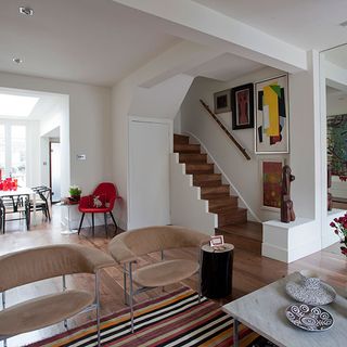 open plan ground floor with white wall and stairs